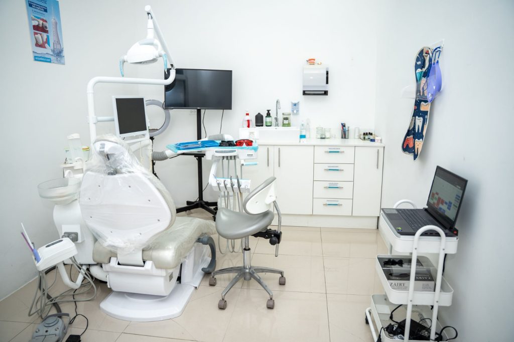 Uno de los consultorios de la clínica, con el sillón dental, la lámpara y los monitores.